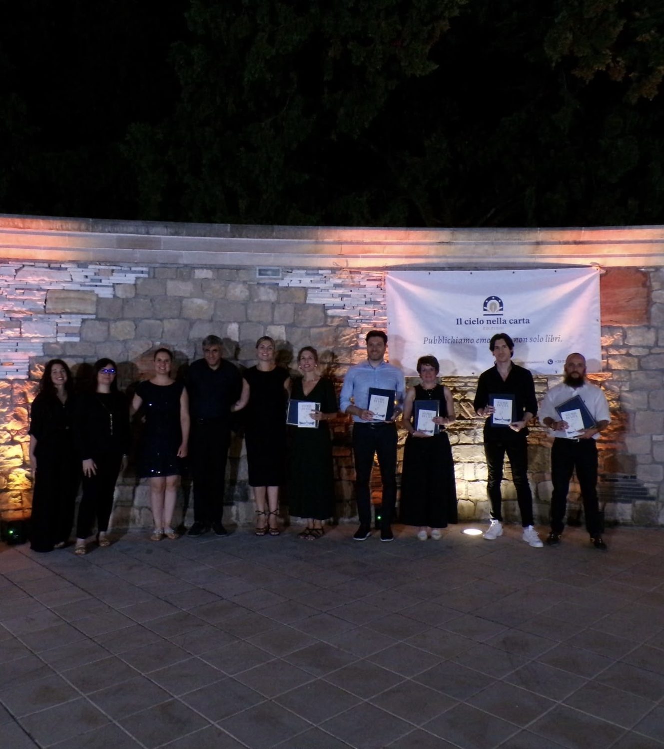 Una fotografia di gruppo, con i libri e i riconoscimenti della serata.